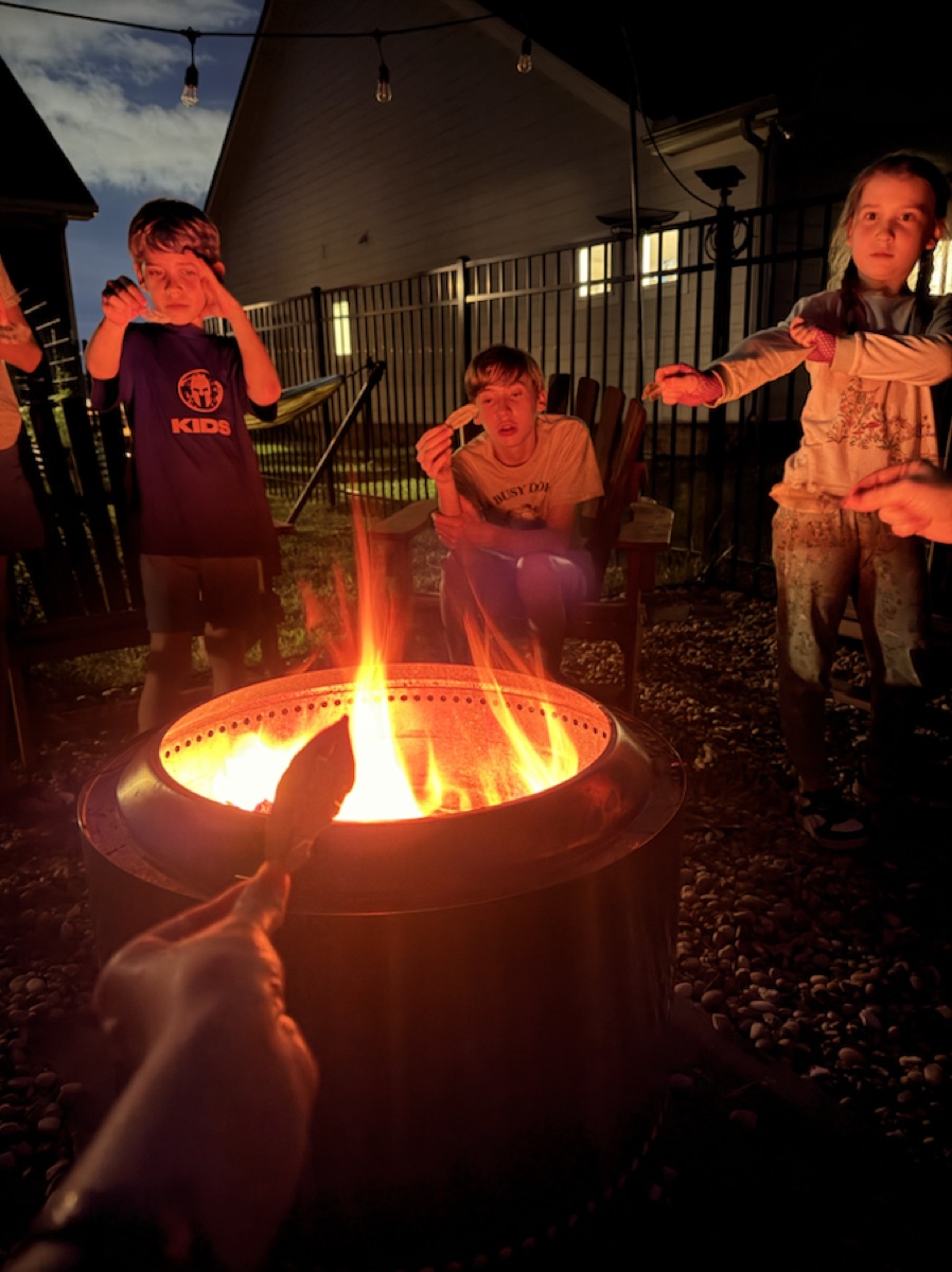 Children gathered around a glowing fire at night