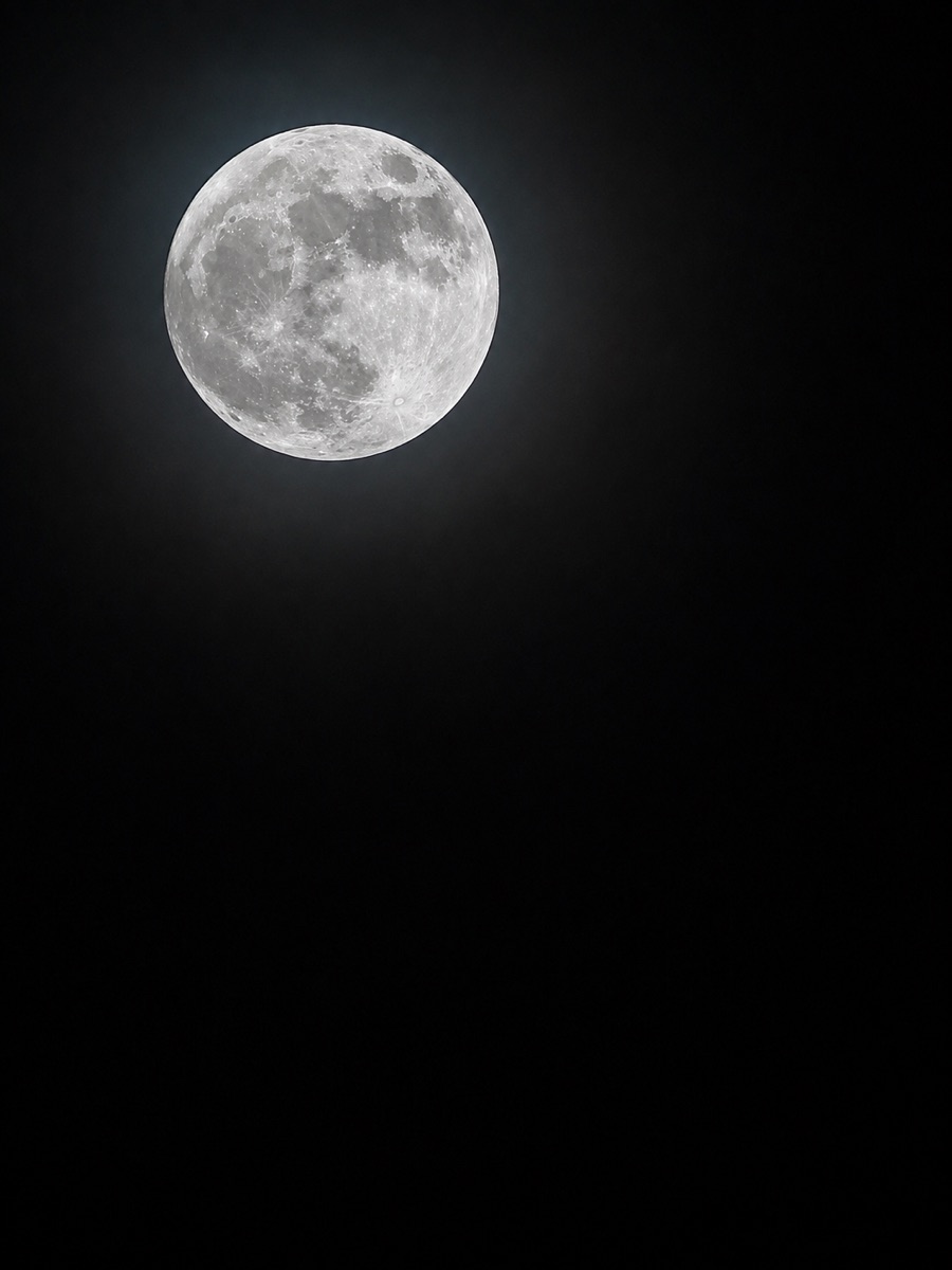 A bright full moon glowing against a dark night sky